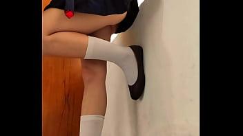 Colegiala follada y llenada de leche de pie contra la ventana en un aula vacía