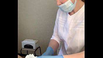 El paciente cum poderosamente durante el procedimiento de examen en manos del médico